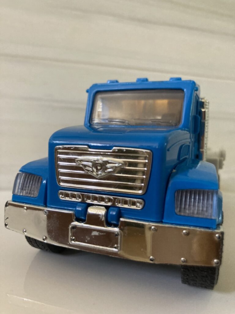 close up of the front of a battat toy truck. the truck is blue.