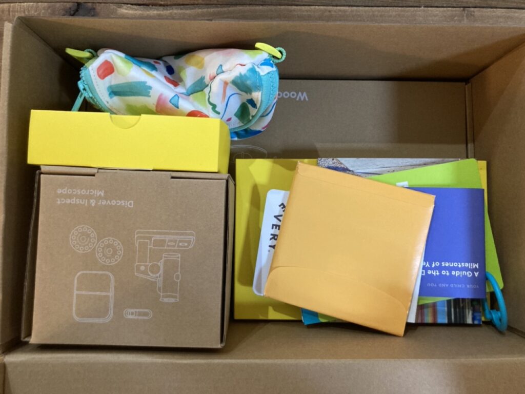 inside contents of the lovevery four year old play kit box, showing smaller boxes of toys, fanny pack and educational guides.