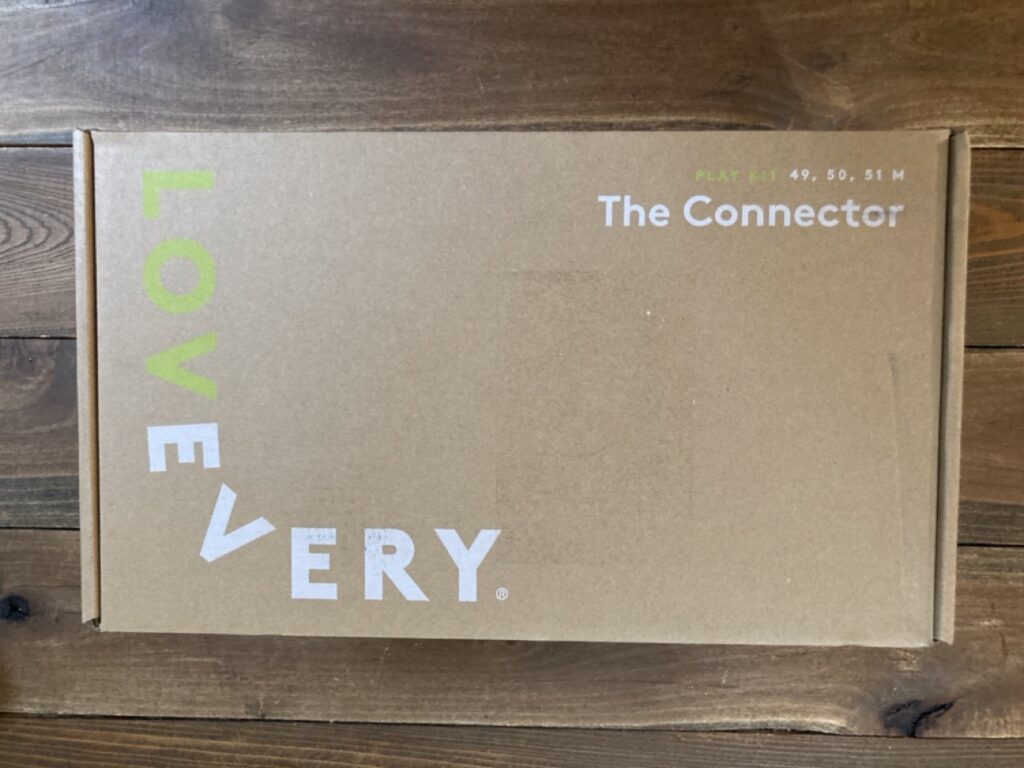 outside of the lovevery 4 year old play kit box. it is a simple brown box with the words 'lovevery' and 'the connector' on it.