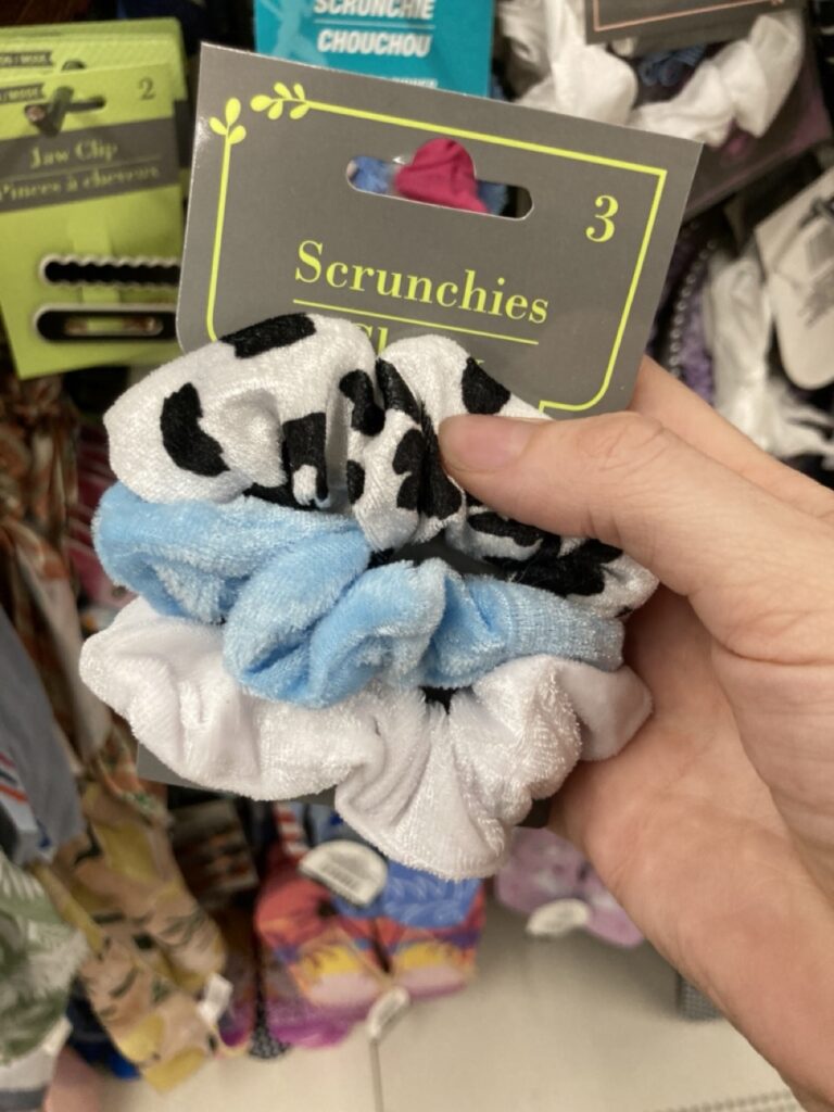 a pack of scrunchies: one black polka dots, one light blue, one white