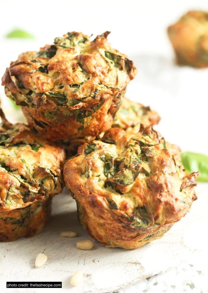 There are three muffins in a stack and they have some spinach in them