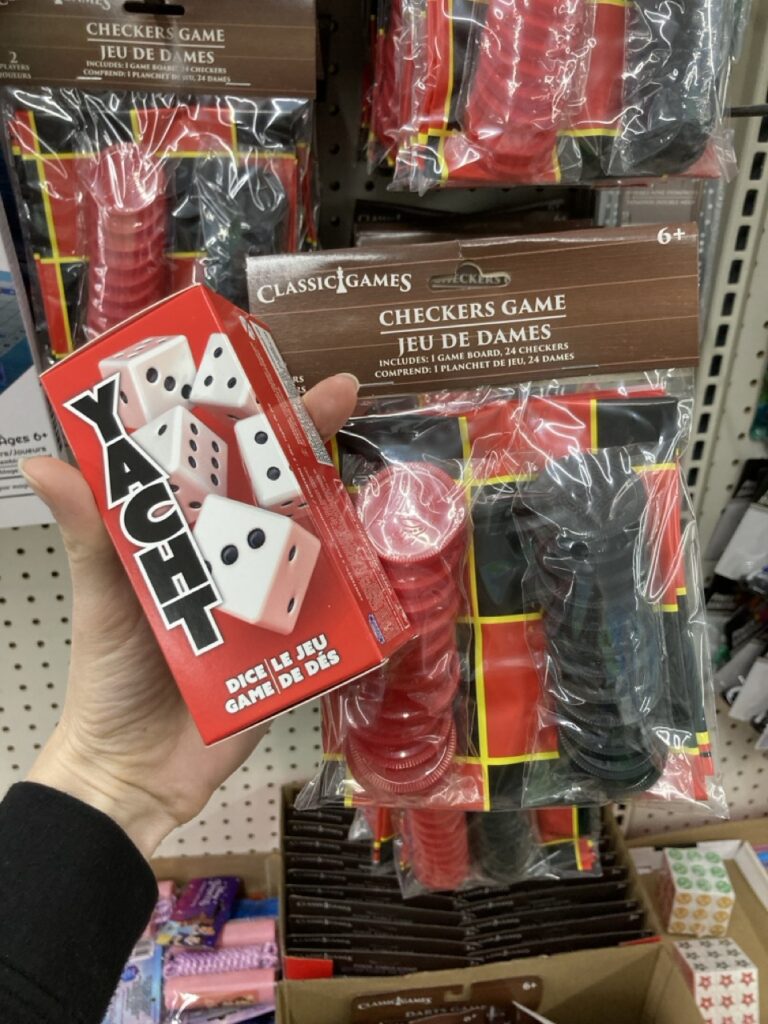 a hand holding up a dice game and a checker game