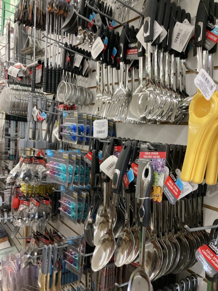 shelf at the dollar tree with kitchen utensils hanging