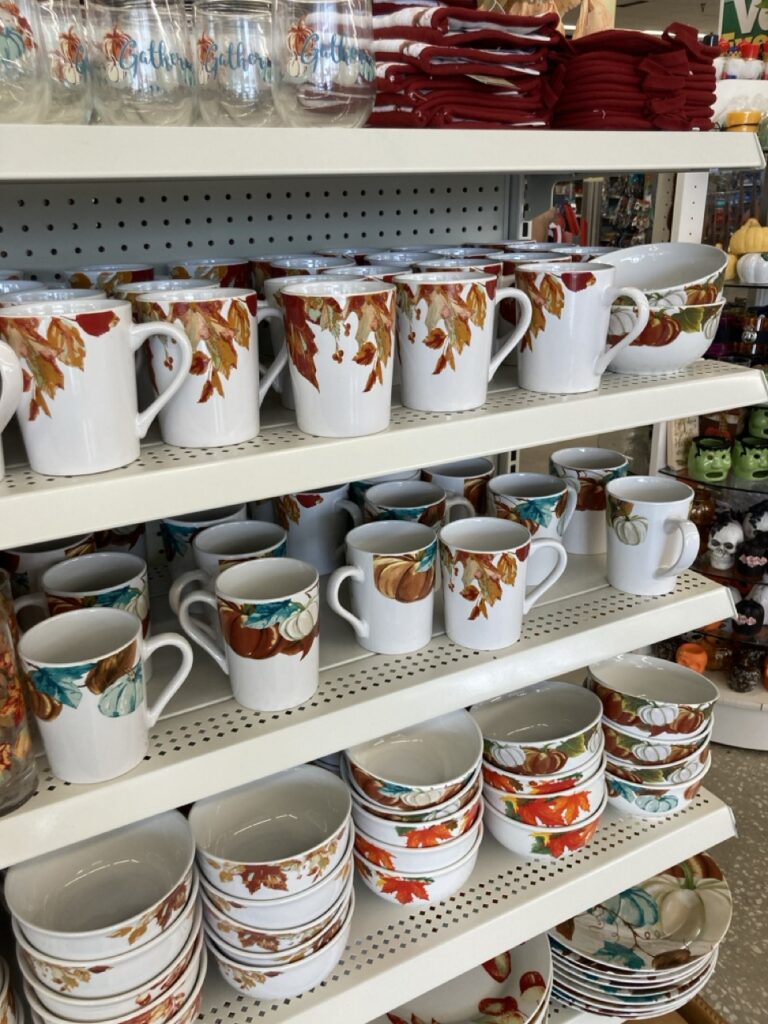 shelves of fall leaf and pumpkin themed plates and mugs