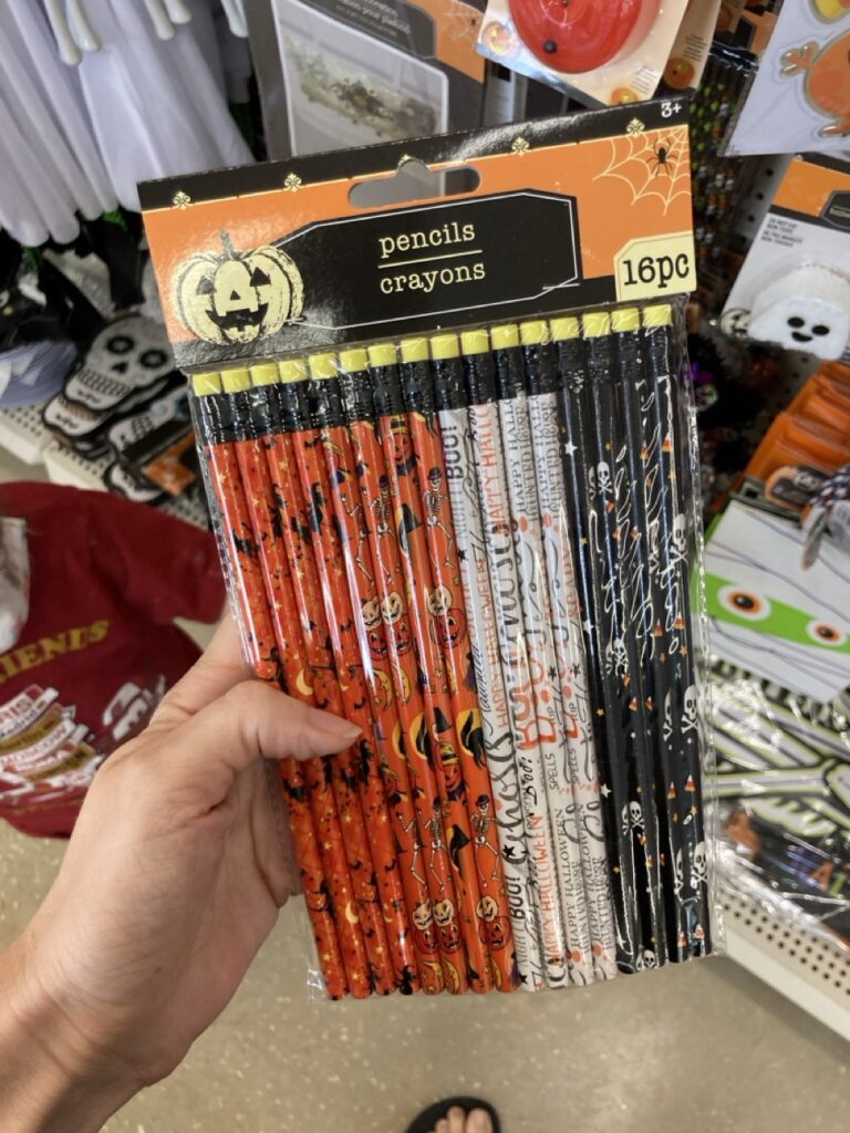 pack of halloween pencils in orange, white and black being held by a hand