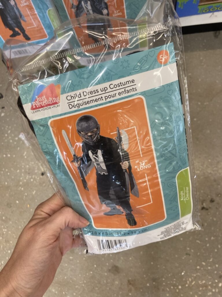 a child's halloween costume in the package being held by a hand