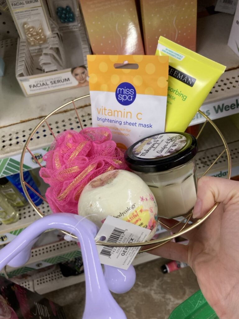 a self care basket with lotions, massager and bath bomb
