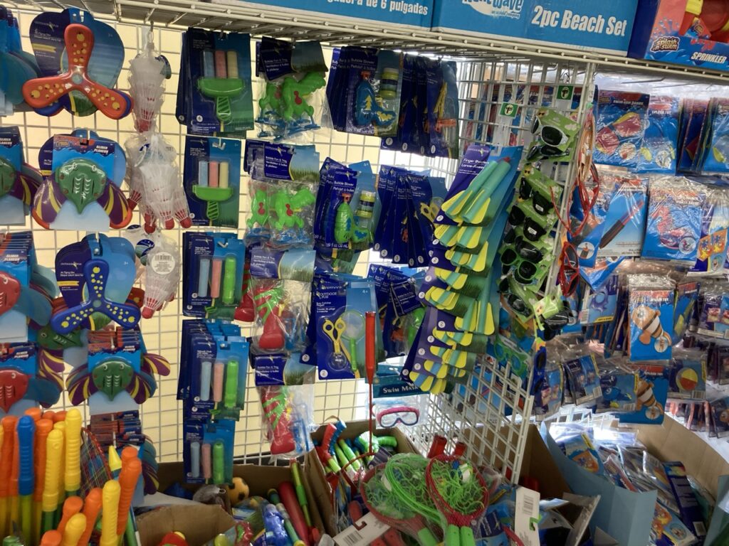 shelf at the dollar tree with summer pool and beach toys hanging