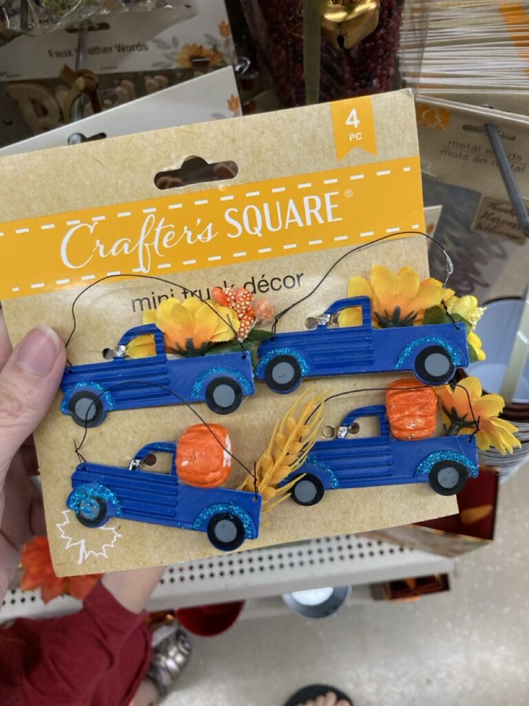 a pack of little blue truck decorations with pumpkins in the back