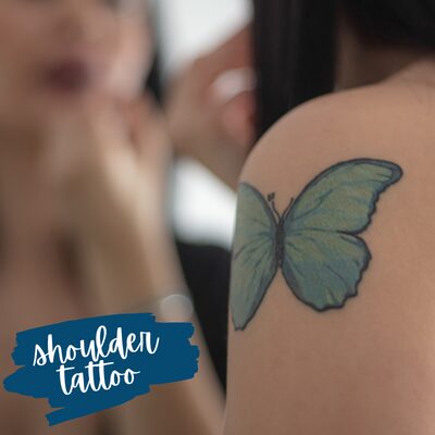 a blue butterfly tattoo on a shoulder