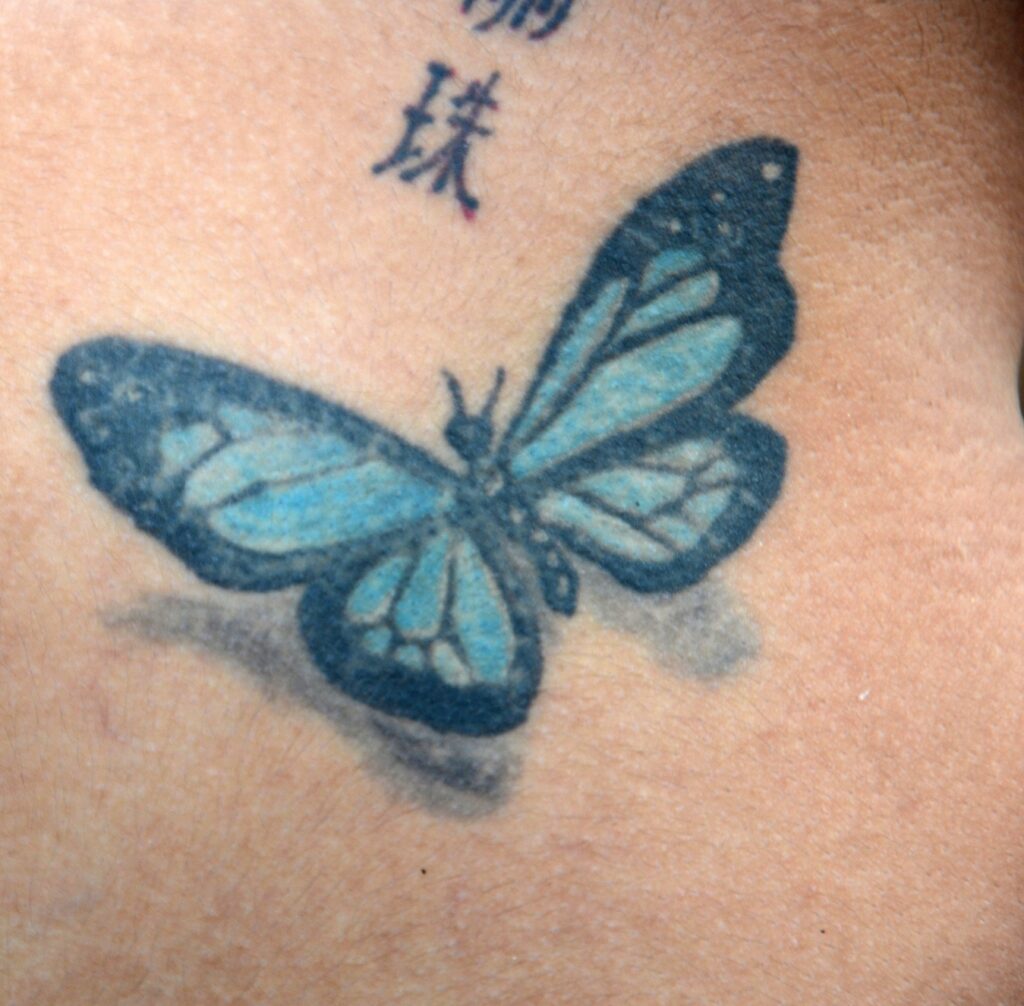 a zoom in on a blue butterfly tattoo