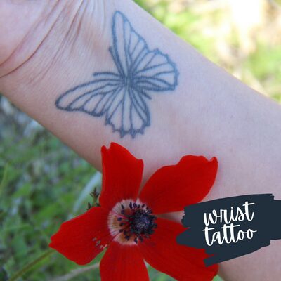 a red flower next to an inner wrist with a butterfly tattoo