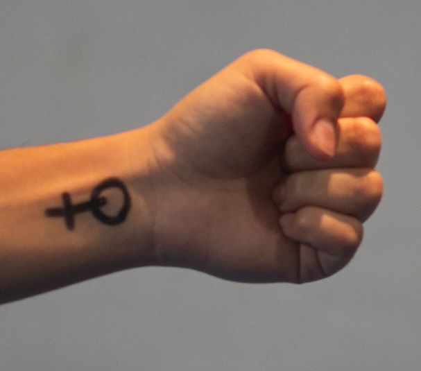wrist with a female symbol on it and the hand is in a fist