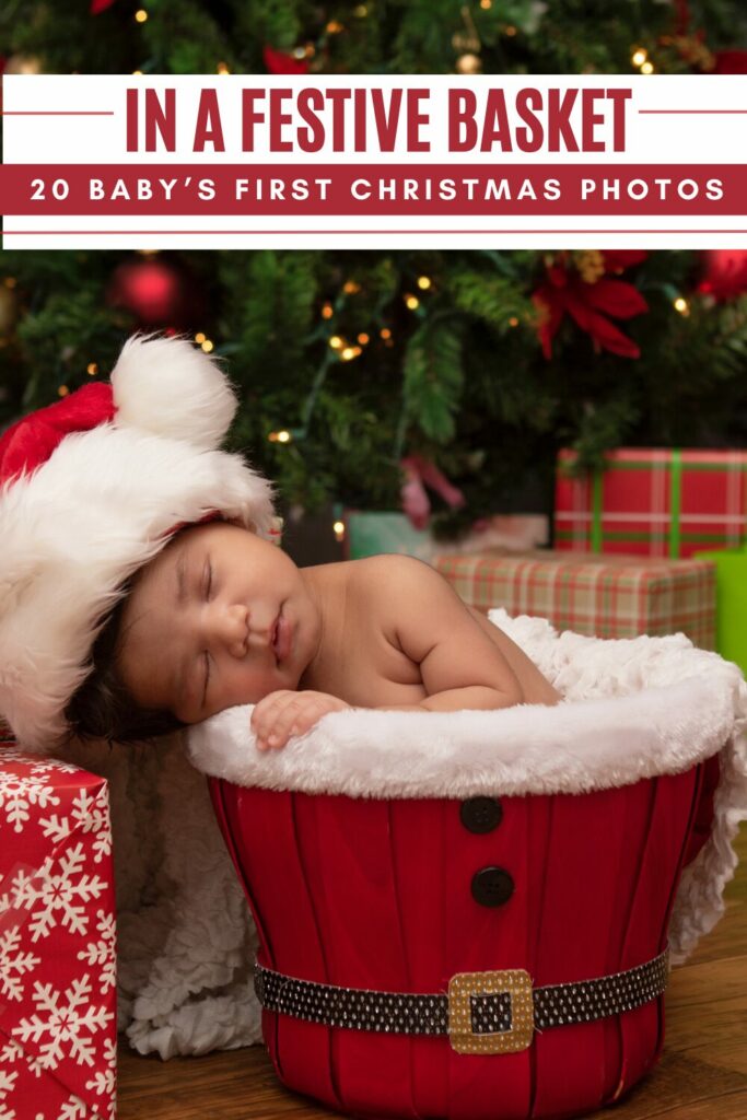baby in a santa hat sleeping in a santa themed basket with christmas tree and presents around them