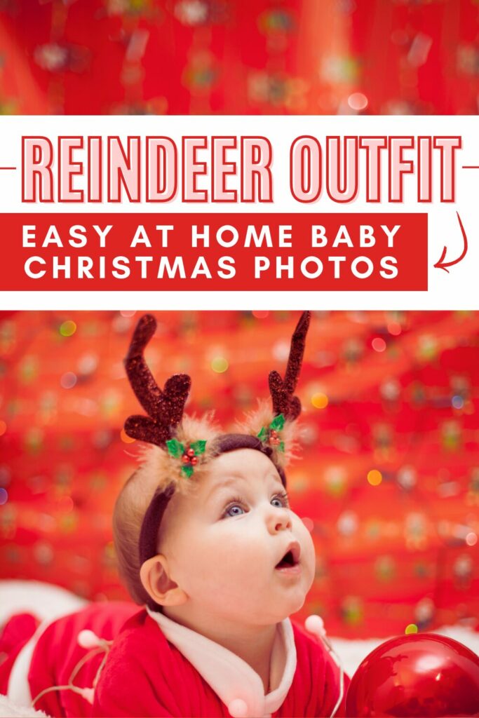 baby in reindeer antlers looking up with a red background behind them