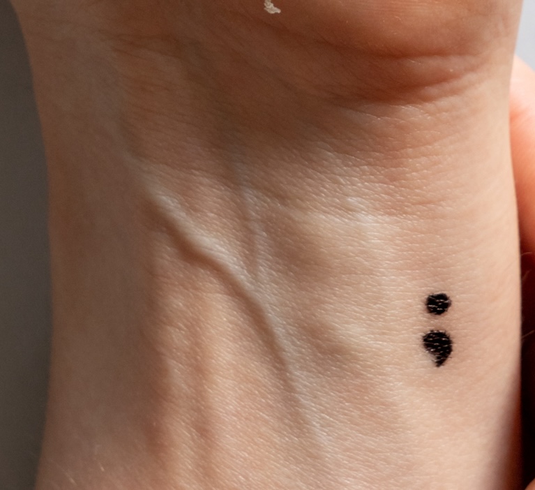 very small semi colon tattoo on the side of the inside wrist