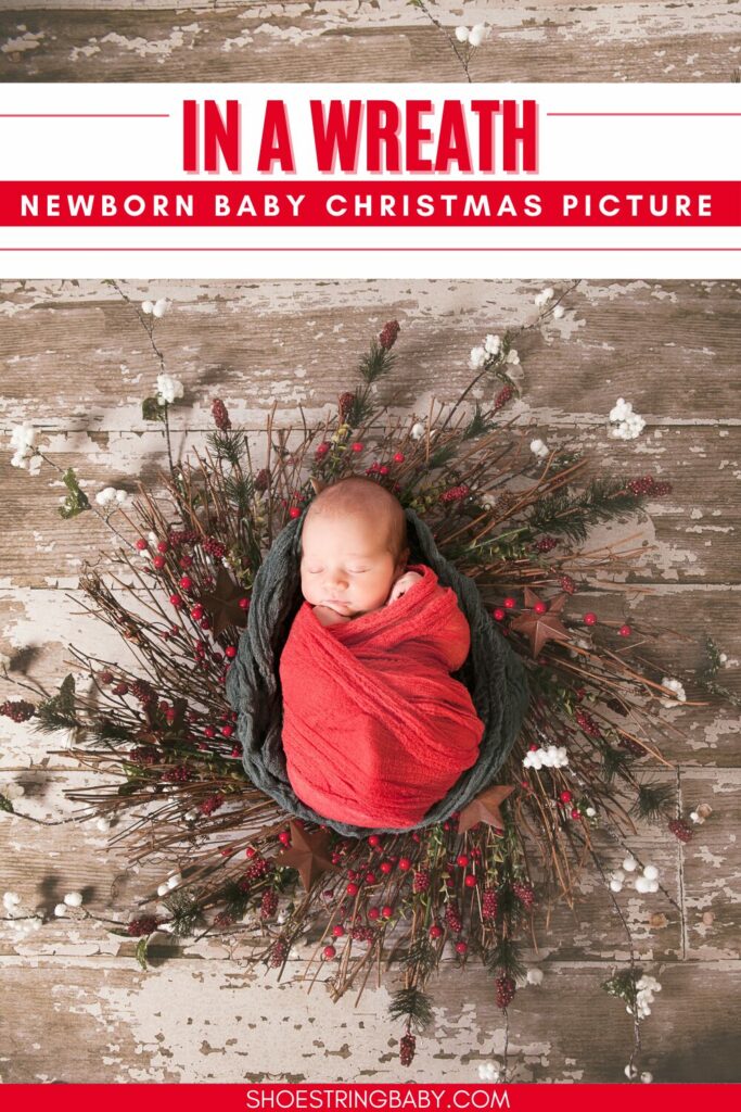 newborn wrapped in a red blanket in the middle of a holly wreath