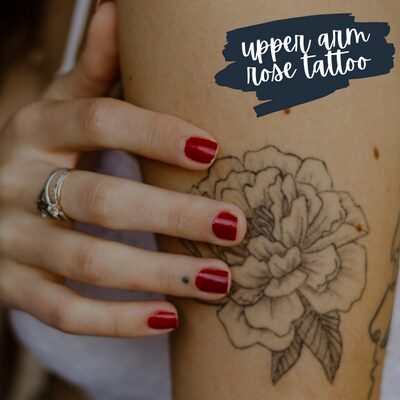 a simple rose upper arm tattoo