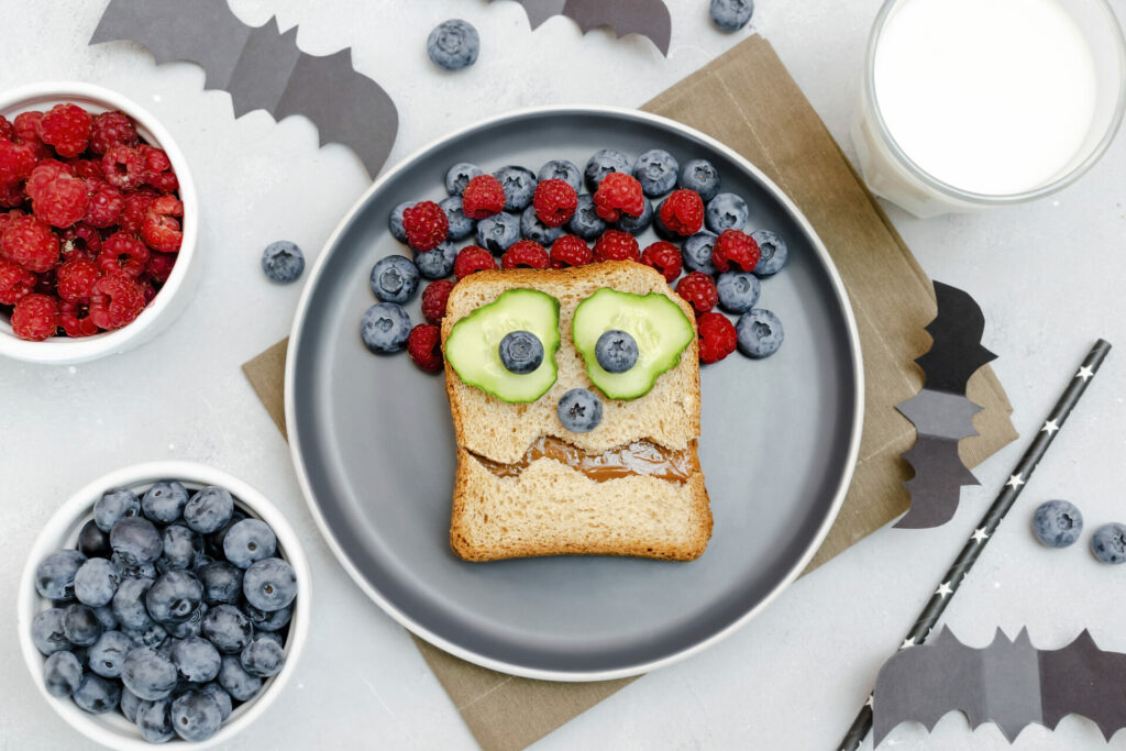 toast made to look like a monster with produce and berries for hair