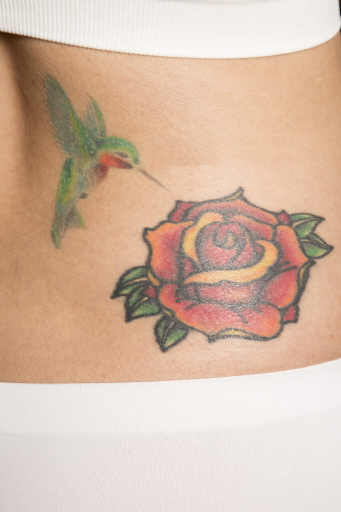 a tattoo of a rose and hummingbird