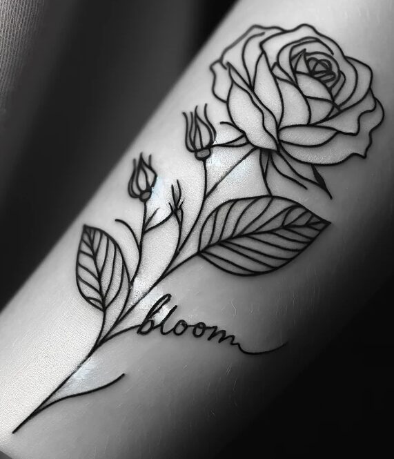 a black and white picture of a rose tattoo that says bloom as a leaf on the stem