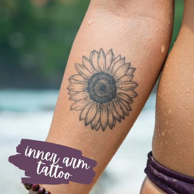 a zoom in on a forearm with a sunflower tattoo on it