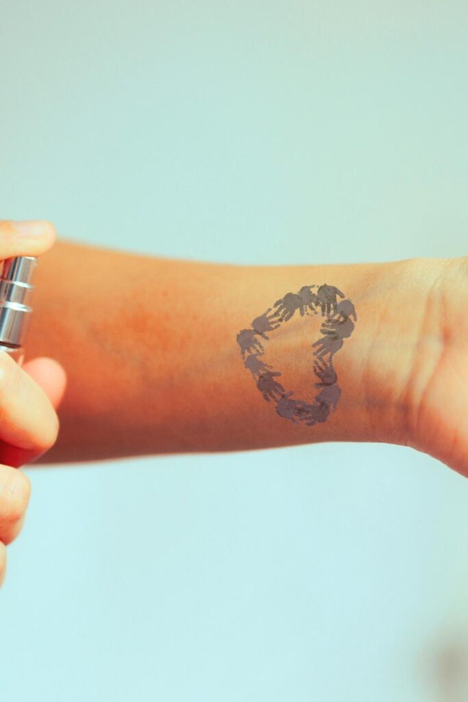 Wrist tattoo of family
handprint shaped into a heart.
