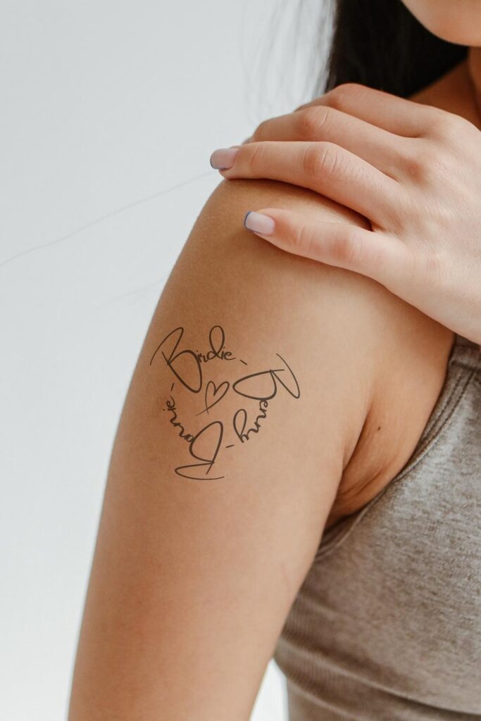 Tattoo of family names on the arm.