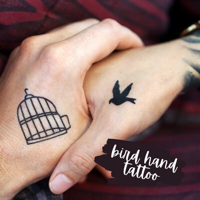 Matching tattoo of a bird and a cage.